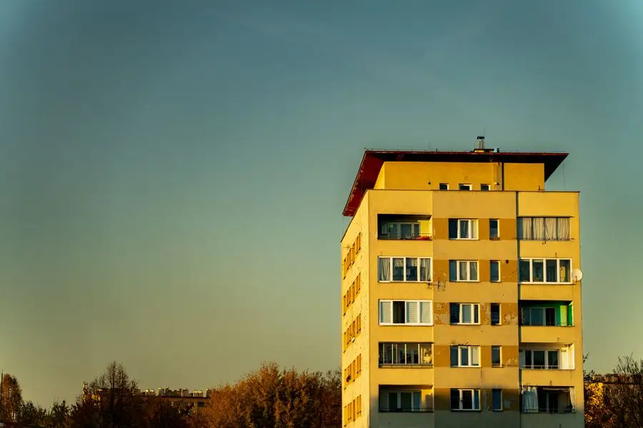 Жилищен блок с жълта фасада, огрян от слънцето